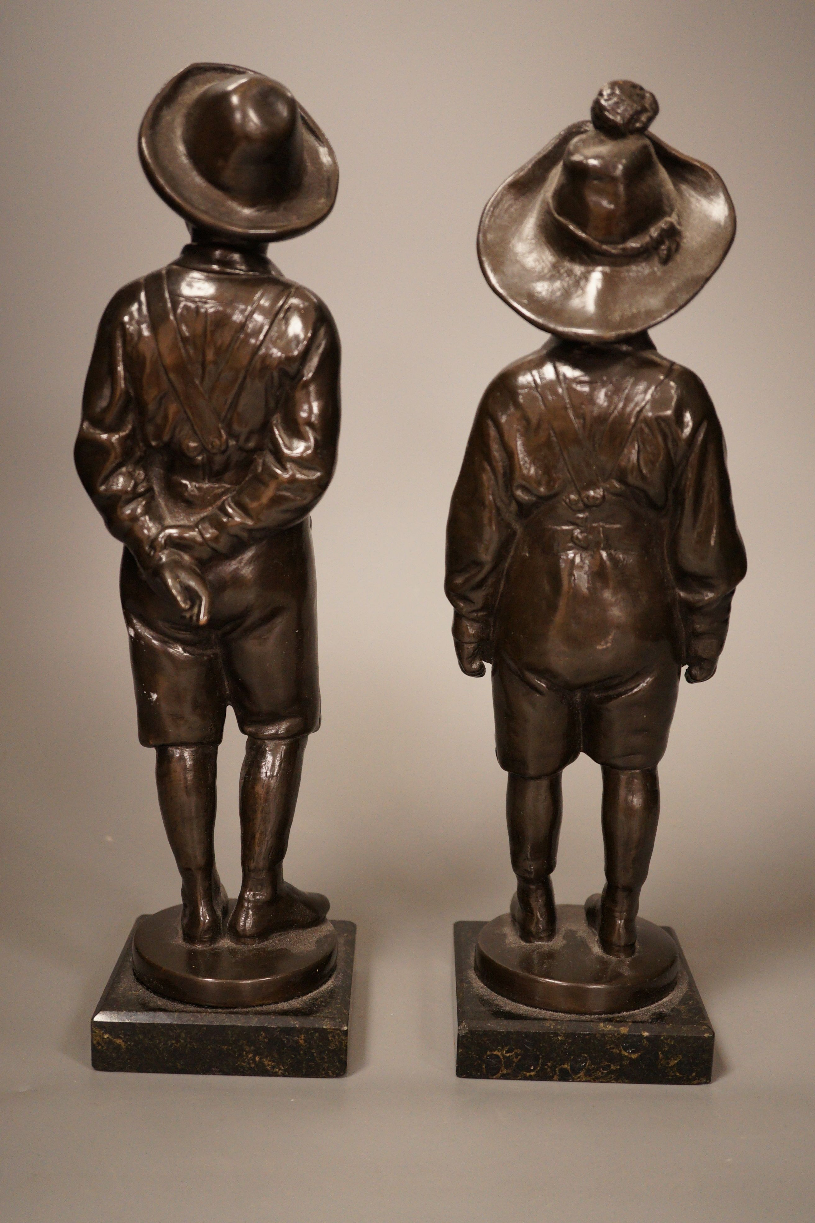 A pair of 20th century patinated metal figures of ruffians, marble bases, tallest 30cm